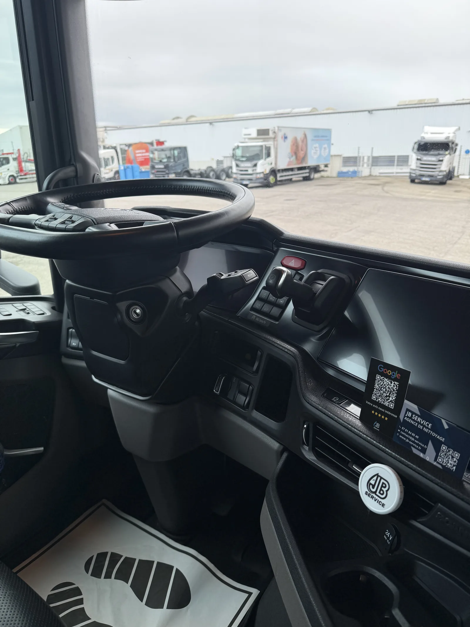 Controle qualite et carte de visite JB Service deposee dans la cabine d'un poids lourd apres nettoyage de flotte a Lyon