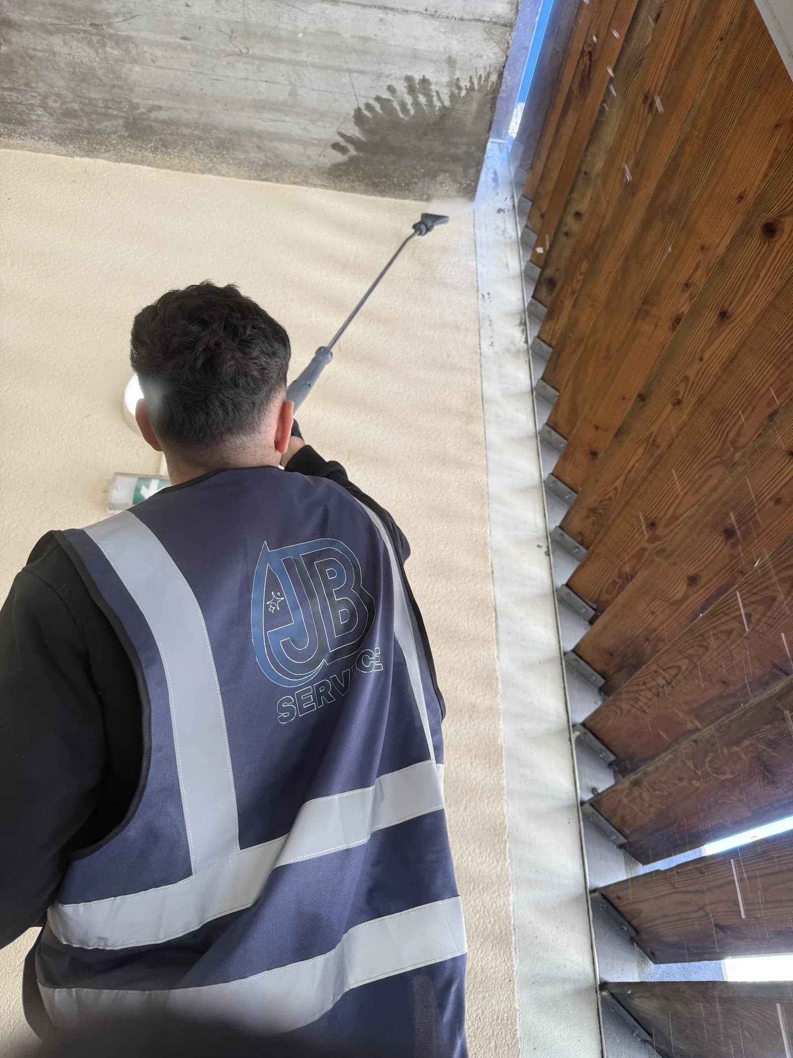 Nettoyage haute pression d'un mur de parking a Lyon avec perche telescopique par un technicien JB Service