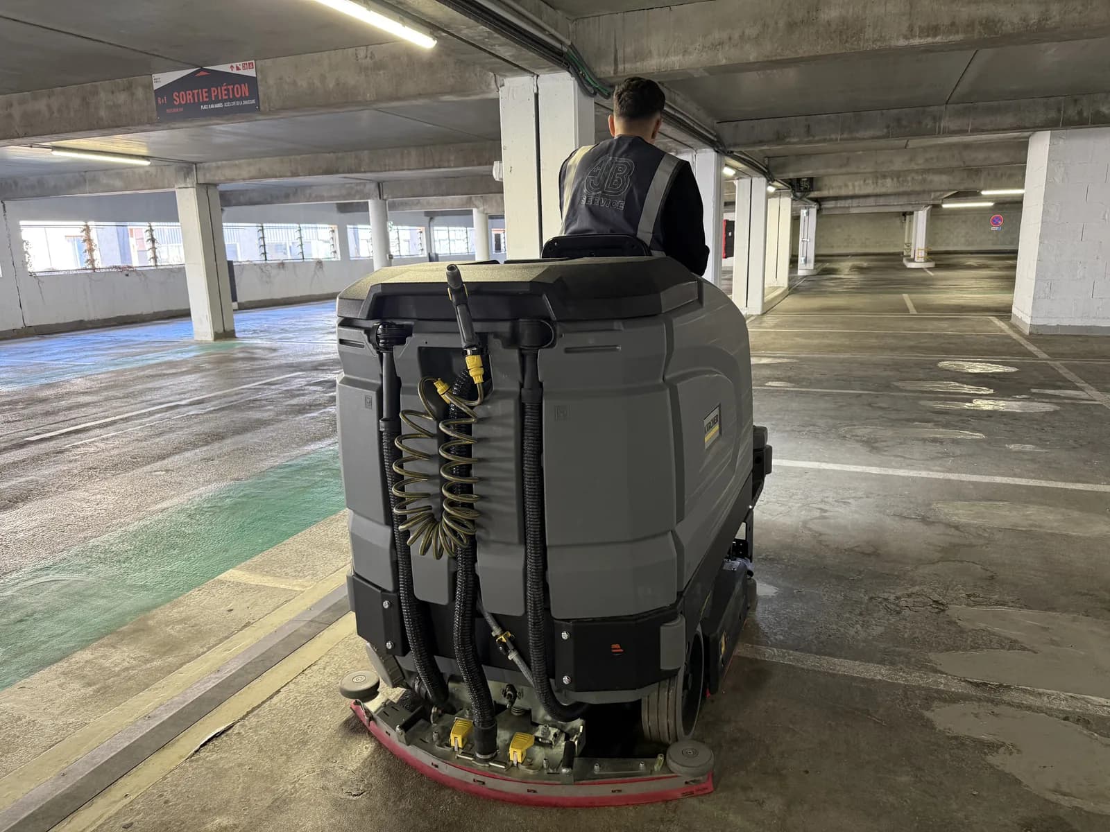 Nettoyage de parking souterrain a Lyon avec autolaveuse autoportee JB Service, vue arriere sur niveaux multiples
